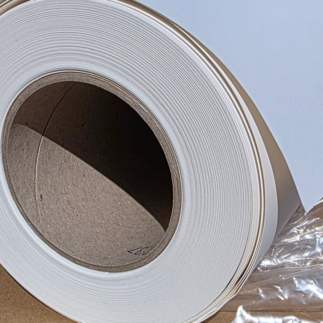 Close-up of a large roll of white paper with a clear plastic wrap.